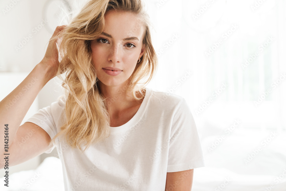 Smiling young beautiful blonde woman wearing t-shirt - obrazy, fototapety, plakaty 