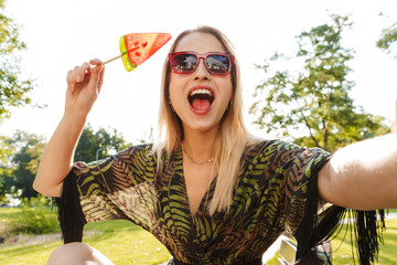 Sticker - Beautiful happy young blonde woman sitting on a bench