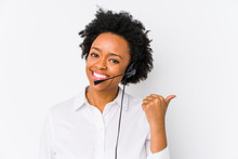Young African American Telemarketer Woman Isolated Points With Thumb Finger Away, Laughing And Carefree.