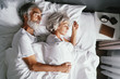 © luengo_ua - Senior family couple sleeping together in bed.