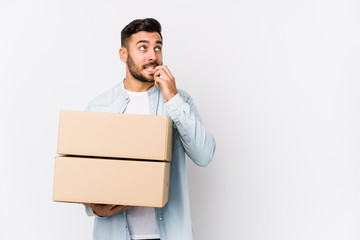 Wall Mural - Young caucasian man moving to a new home isolated relaxed thinking about something looking at a copy space.