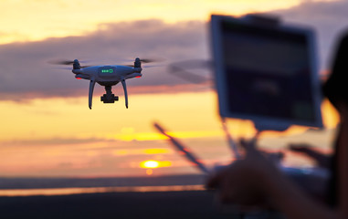 Wall Mural - drone quadcopter with digital camera flying at sunset