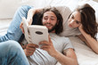 © Drobot Dean - Loving couple indoors at home lies reading book together.