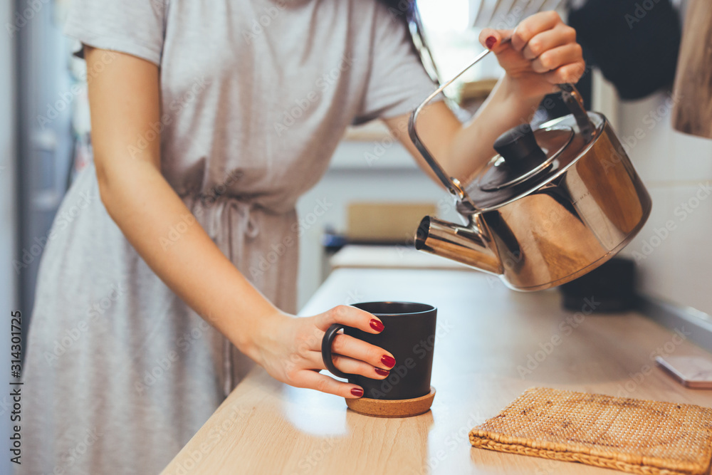woman in kitchen drinking coffee or tea - obrazy, fototapety, plakaty 