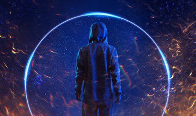 Back view of hacker in hoodie. Dangerous hooded hacker. Internet, cyber crime, cyber attack, system breaking and malware concept. Anonymous. Dark background, fire flares.