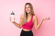 © luismolinero - Young sport blonde woman over isolated pink background with sports water bottle
