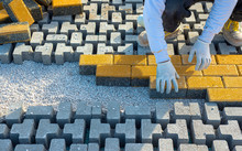 Paving Stone Worker Is Putting Down Pavers During A Construction Of A City Street.