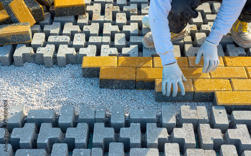 Cuadros en Lienzo Paving stone worker is putting down pavers during a construction of a city street