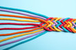 © New Africa - Braided colorful ropes on light blue background, top view. Unity concept