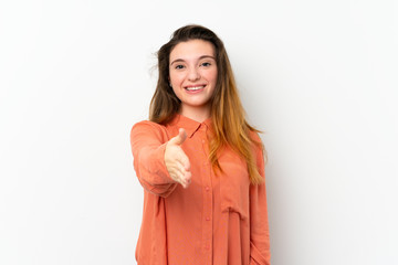 Wall Mural - Young brunette girl over isolated white background shaking hands for closing a good deal