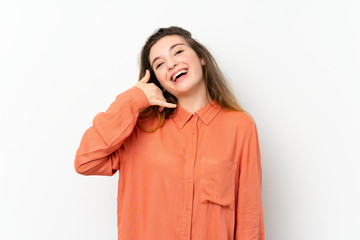 Wall Mural - Young brunette girl over isolated white background making phone gesture. Call me back sign