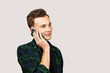 © vika33 - man talking on phone and smiling. Happy young guy in a joyful conversation at telephone with copy space.