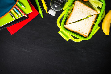 Wall Mural - Back to school concept. Lunch box with stationery on black.