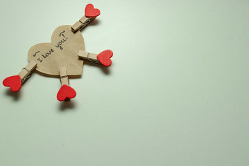 White background. A small wooden clothespin with a red heart. Valentine's day.