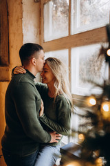 A guy with a girl is celebrating Christmas. A loving couple enjoys each other on New Year's Eve in a cozy home environment. New Year's love story.