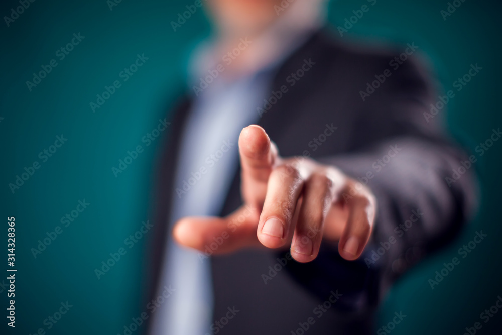 Businessman in suit pressing virtual button or pointing at something - obrazy, fototapety, plakaty 