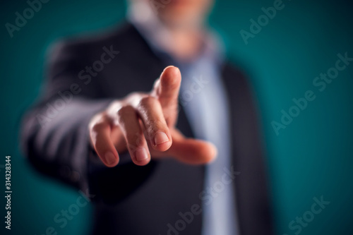 Fotografía Businessman in suit pressing virtual button or pointing at something