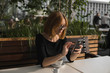 © Volodymyr_sh - Young business woman uses phone. Good looking brunette female uses online banking on smart phone to transfer money from credit card. Girl using smart phone and chatting with business partners in cafe.