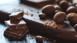 Fototapeta Mapy - Various candies and chocolate with cocoa powder on a dark wooden surface