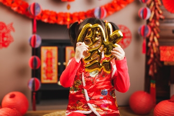 Wall Mural - Chinese toddler girl traditional dressing up hold a Fu means 'lucky' greeting sign