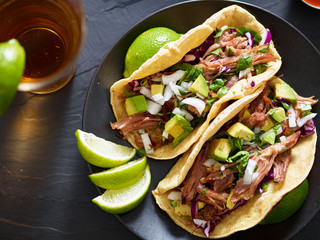 tasty pork street tacos with onion, cilantro, avocado, and red cabbage