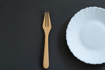 Empty white plate on wooden table top view