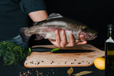 Fototapeta Tęcza - large fresh fish in the kitchen in the hands of the chef