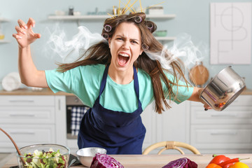 Aggressive young housewife with steam coming out of ears in kitchen