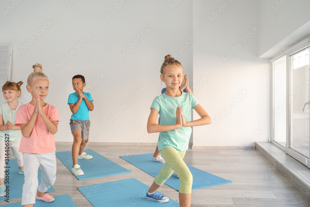 Little children practicing yoga in gym