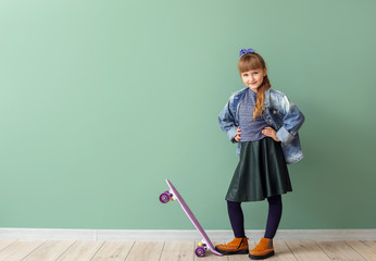 Wall Mural - Cute fashionable girl with skateboard on color background