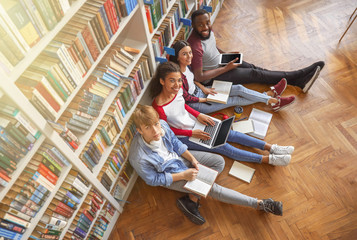 Canvas Print - Young students preparing for exam in library