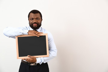 Wall Mural - African-American teacher with chalkboard on white background