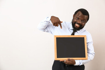 Wall Mural - African-American teacher with chalkboard on white background