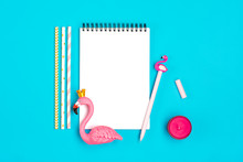 Notebook, Pen, Flamingo Figure, Smartphone, Candle, Drinking Paper Straws On Blue Background Travel, Pool Party,  Art And Creative Concept Place For Text Summer Party Holiday Card