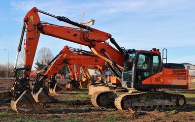 Row of excavators lined up in a construction site of a redevelopment urban area	