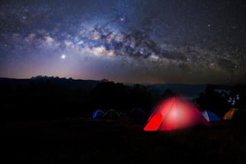camping and tent under the with forest near in the mountains . a tent pitched up and glowing under t