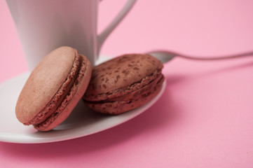 Sticker - Closeup of french macarons on cup of coffee on pink background