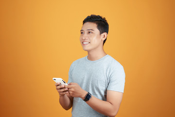 Sticker - Smart casual asian man using smartphone in orange background.