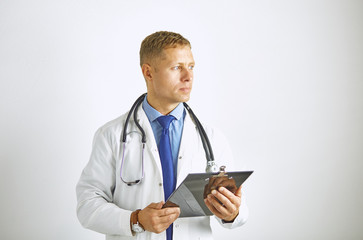 Wall Mural - Young confident doctor in a white coat with a stethoscope