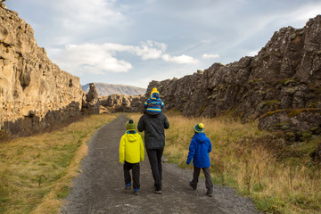 Father with three children, enjoying a sunny day in Thingvellir National Park rift valley, Iceland