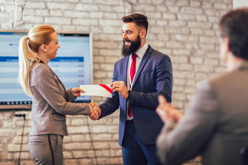 Businessman receiving award from businesswoman