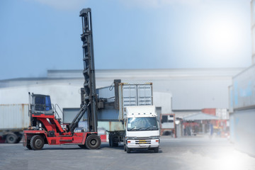 Container handlers are loading containers into trucks.