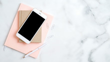 Home Office Desk Workspace With Smartphone Screen Mockup, Pink Notepad, Pen On Marble Background. Flat Lay, Top View. Elegant Feminine Workplace With Stylish Accessories