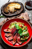 Fototapeta Natura - Warm salad with roast beef on a red plate. A dietary meal for a healthy diet