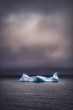 Dramatic image of an iceberg floating in dark