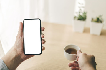 Mockup image blank white screen cell phone.man hand holding texting using mobile on desk at office.background empty space for advertise text.people contact marketing business,technology 