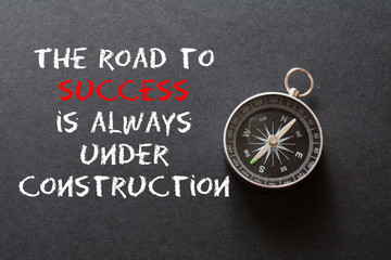 Wall Mural - Motivational quote the road to success ,on black background with compass