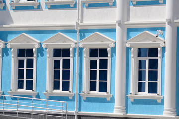 Row of white windows on a blue building