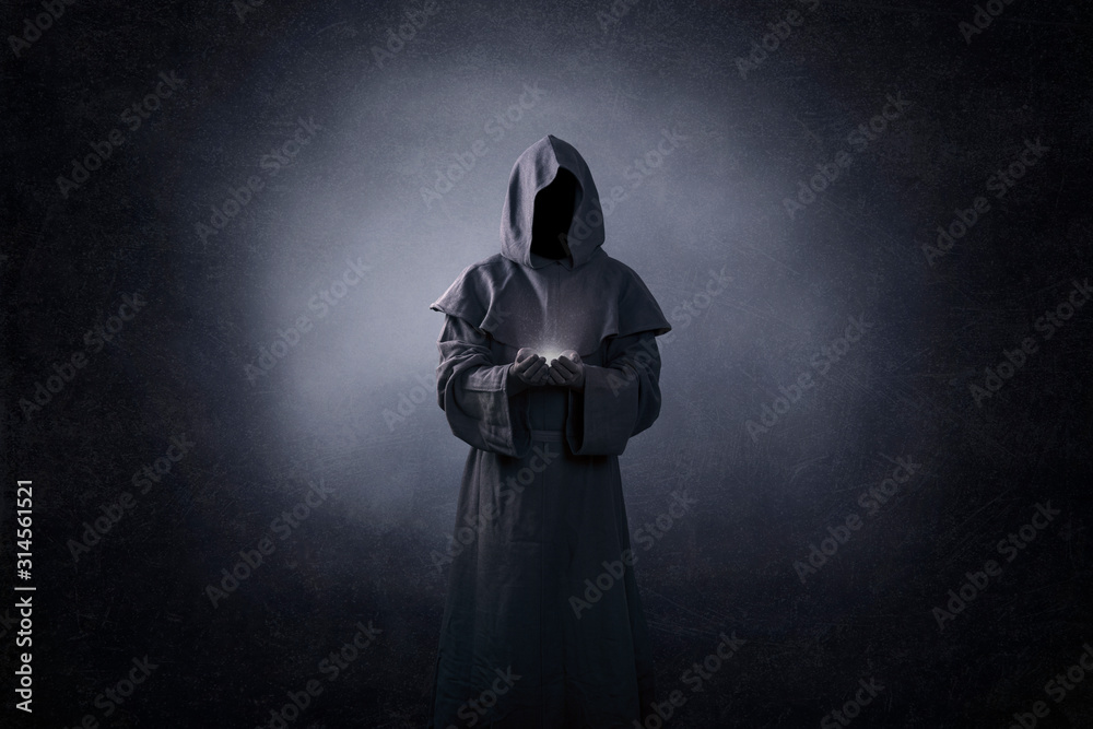 Ghostly figure with light in hands in the dark - obrazy, fototapety, plakaty 