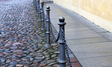 Fence Posts Chains On The Sidewalk